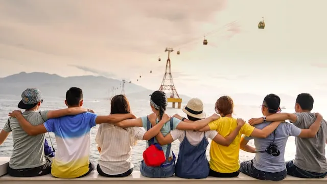 Grupo de personas abrazándose frente a un paisaje